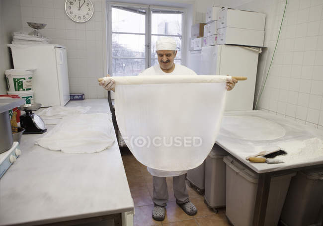 Chef holding pastry at commercial kitchen, focus on foreground — Stock Photo