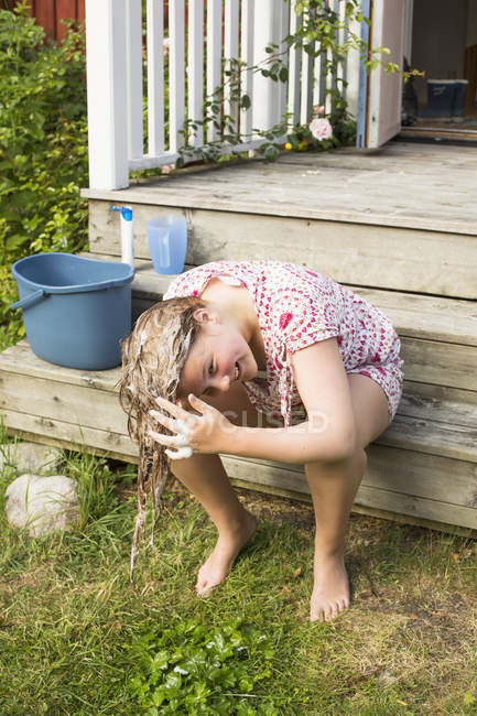 Mädchen wäscht Haare draußen — Stockfoto