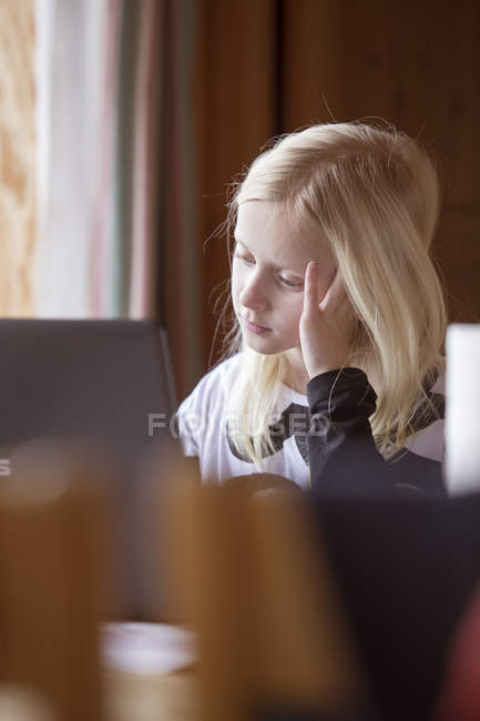Девушка смотрит на экран компьютера, дифференциальный фокус — стоковое фото