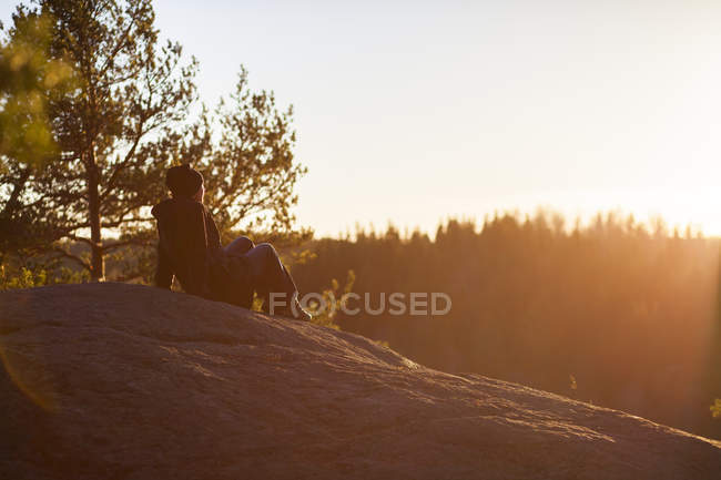 Жінка дивиться на захід сонця, вибірковий фокус — стокове фото