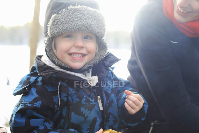 Smiling little girl wearing fur hat, focus on foreground — Stock Photo