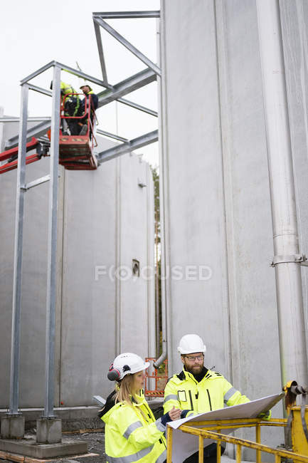 Cuatro personas trabajando en planta de tratamiento de agua - foto de stock