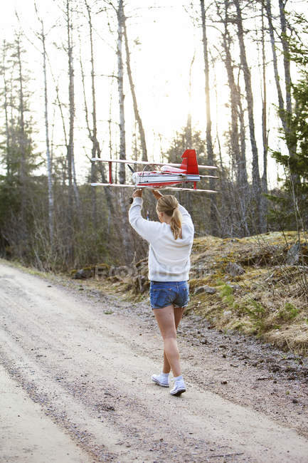Girl carrying plane over head, selective focus — Stock Photo