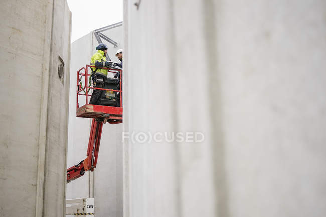 Two construction workers standing on cherry picker, differential focus — Stock Photo