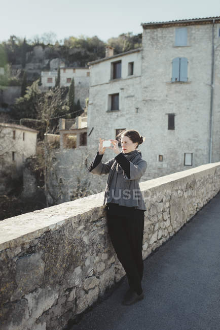 Молодая женщина фотографирует на смартфоне — стоковое фото