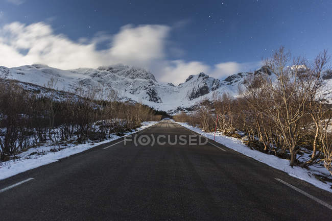 Ruta rural nevada con vista a la montaña en Lofoten, Noruega - foto de stock