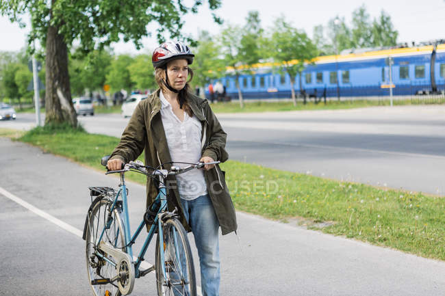 Woman with bicycle looking away, selective focus — Stock Photo