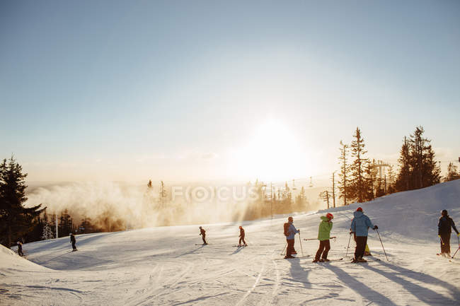 Sciatori sulla montagna innevata al tramonto, focus selettivo — Foto stock