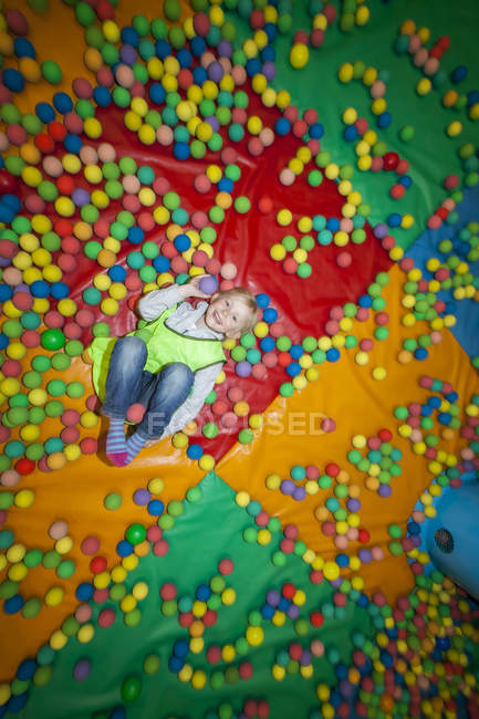 High angle view of girl in ball pool, differential focus — Stock Photo