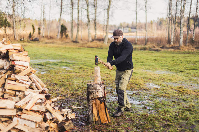Homem que divide a madeira de fogo, foco seletivo — Fotografia de Stock