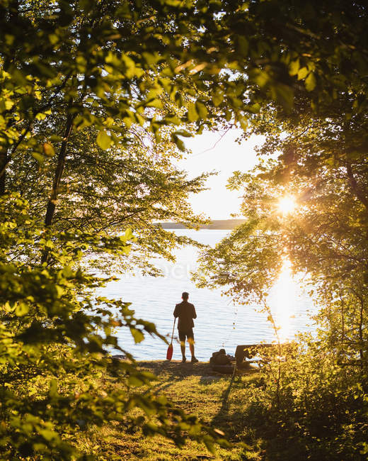 Silhouette dell'uomo in piedi con remo al tramonto — Foto stock