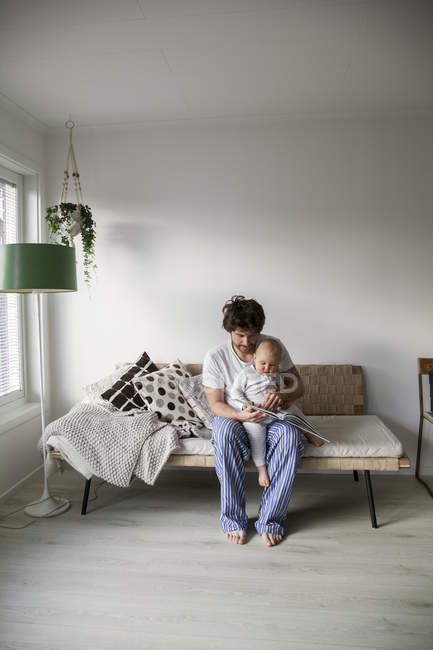 Батько читає дитині сина у вітальні, вибірковий фокус — стокове фото