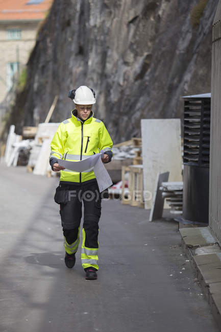 Bauarbeiter betrachtet Baupläne, konzentriert sich auf den Vordergrund — Stockfoto