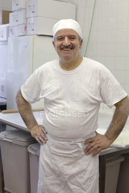 Retrato de chef na cozinha comercial olhando para a câmera — Fotografia de Stock