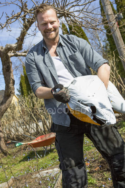 Человек, работающий в саду, сфокусирован на переднем плане — стоковое фото