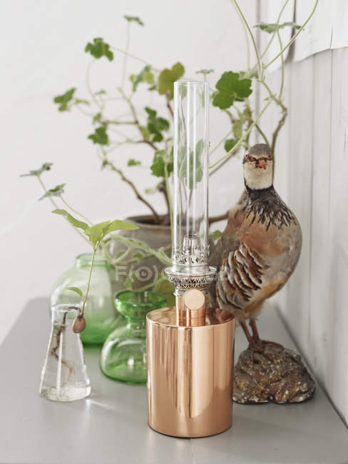 Figurina de pássaro e lâmpada elétrica na mesa — Fotografia de Stock