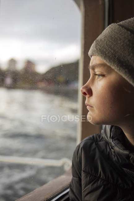 Хлопчик дивиться з вікна човна — стокове фото