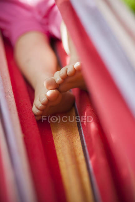 Child in striped hammock, differential focus — Stock Photo