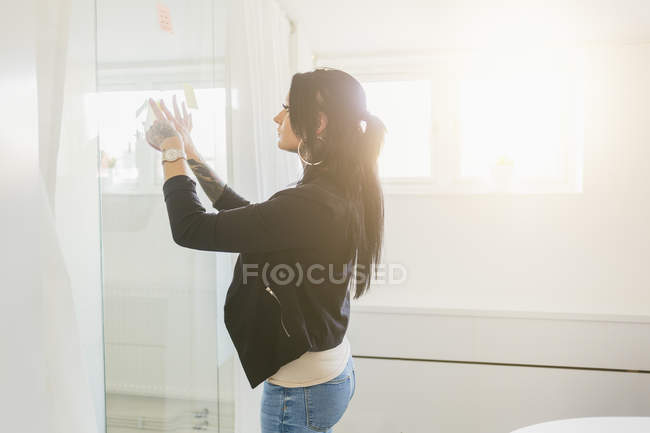 Mulher colocando notas na janela, foco seletivo — Fotografia de Stock