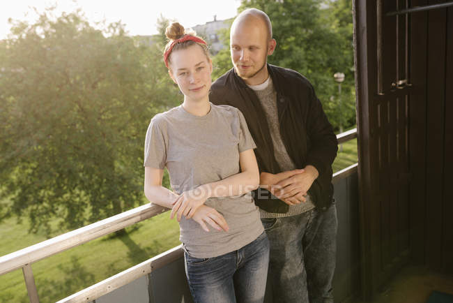 Jeune couple debout sur le balcon — Photo de stock
