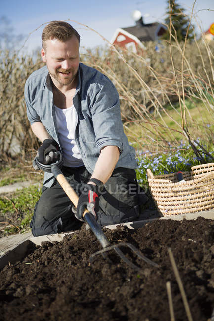 Homem trabalhando no jardim, foco em primeiro plano — Fotografia de Stock