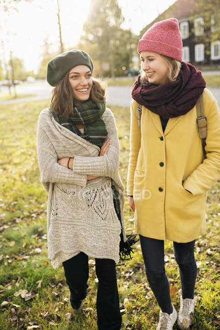 Two young women walking in park, focus on foreground — Stock Photo