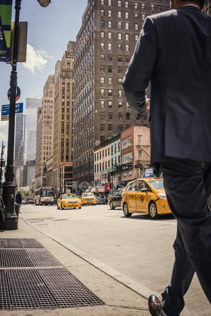 Homme d'affaires marchant sur le trottoir de New York — Photo de stock