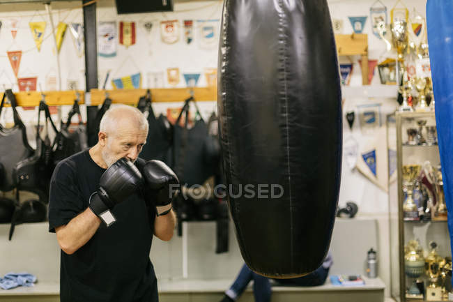 Senior man at boxing training, focus on foreground — Stock Photo