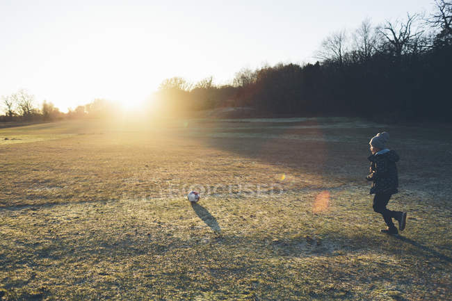 Вид збоку хлопчика, який грає у футбол — стокове фото