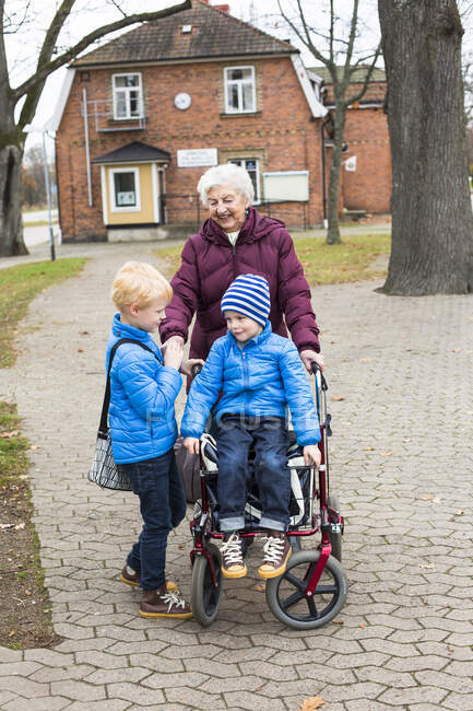 Улыбающаяся прабабушка и двое детей на открытом воздухе — стоковое фото
