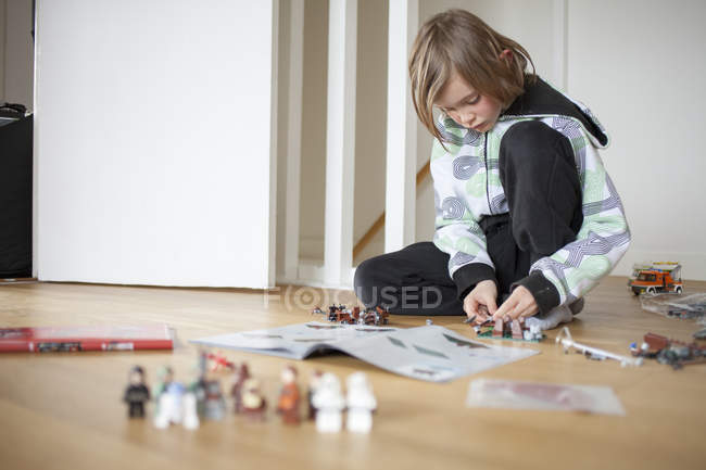 Menino em roupas casuais jogando na sala de estar — Fotografia de Stock