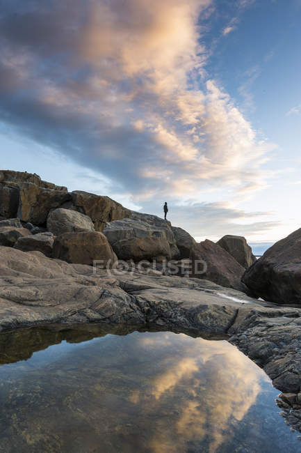 Piscina rocciosa in riva al mare, donna sullo sfondo — Foto stock