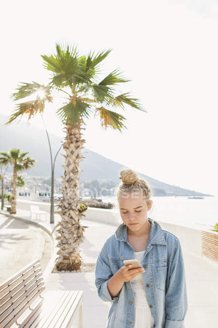Молодая женщина смотрит на смартфон, сосредоточиться на переднем плане — стоковое фото