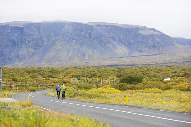 Два велосипедиста на сельской дороге в Исландии — стоковое фото