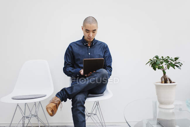 Freelancer using digital tablet against white wall — Stock Photo