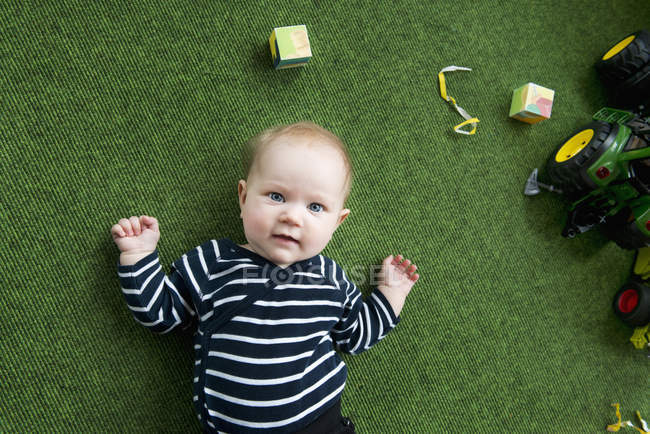 Baby lying on floor and looking up — Stock Photo