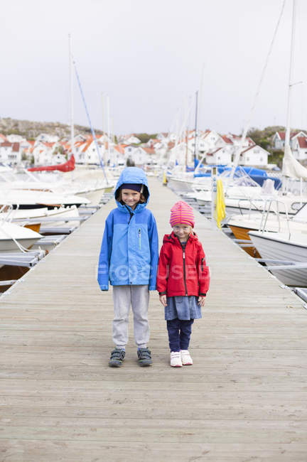 Portrait of siblings on pier, focus on foreground — Stock Photo