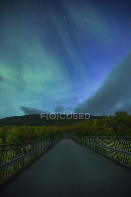 Rural road at night with northern lights in Sweden — Stock Photo