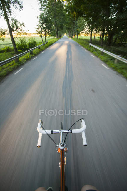 Perspectiva personal del hombre en bicicleta, movimiento borroso - foto de stock