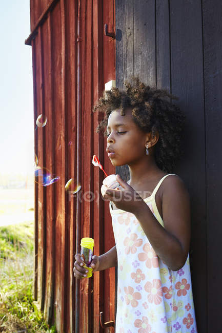 Girl blowing soap bubbles, selective focus — Stock Photo