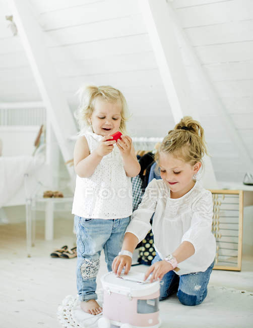 Sisters playing with toy truck in bedroom — Stock Photo