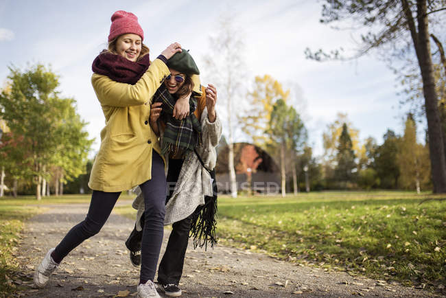 Two young women grappling outdoors, focus on foreground — Stock Photo