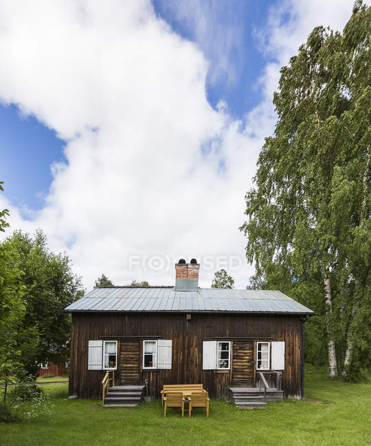Casa de madera cerca de árboles verdes en el norte de Suecia - foto de stock