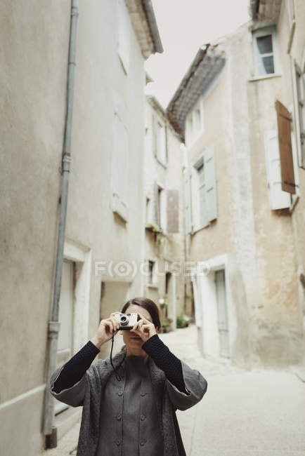 Junge Touristin mit Kamera in enger Straße — Stockfoto