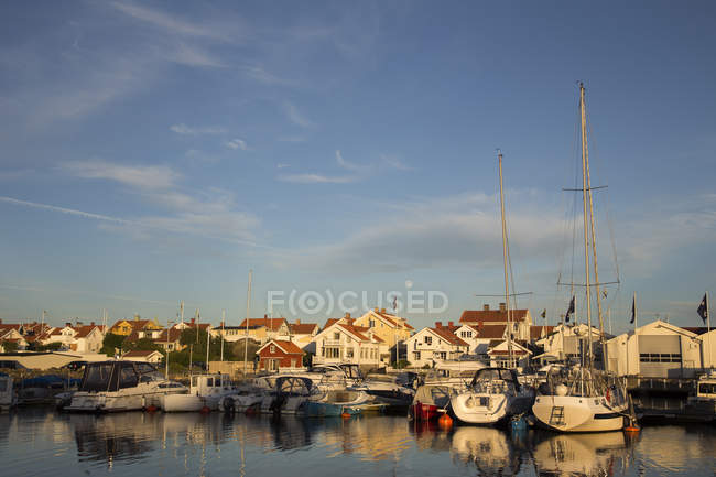 Marina avec bateaux à moteur en mer au coucher du soleil — Photo de stock