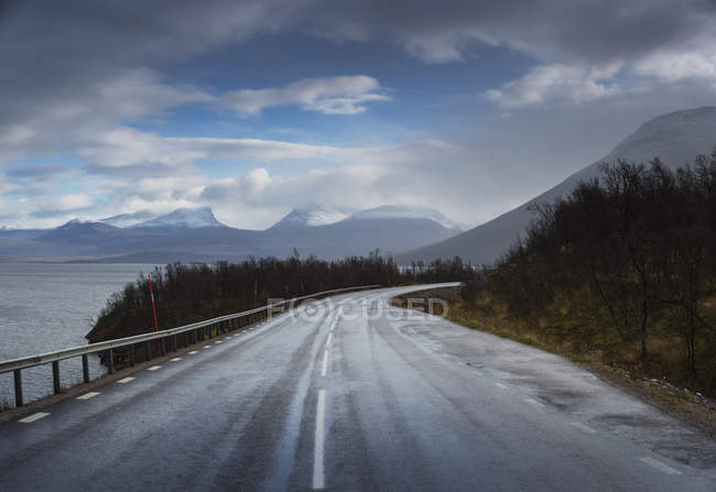Camino rural bajo nubes de tormenta en Suecia - foto de stock