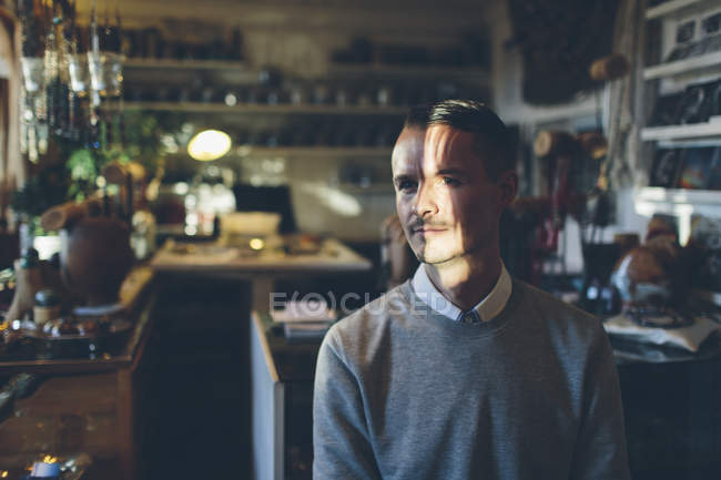 Jeweler with moustache in store, focus on foreground — Stock Photo