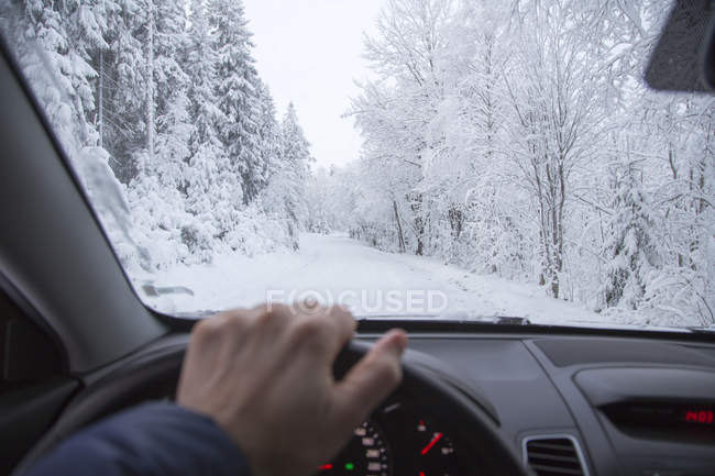 Homem dirigindo na floresta no inverno, foco no fundo — Fotografia de Stock