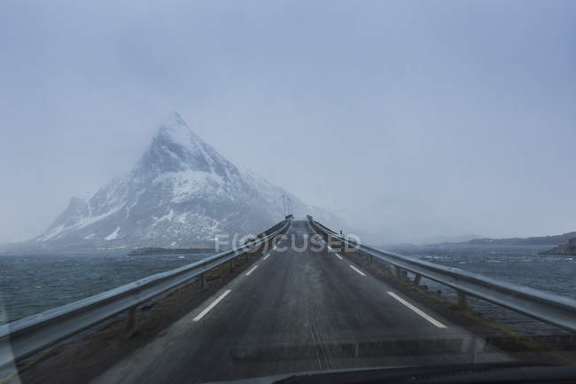 Bridge with view of snow capped mountains — Stock Photo