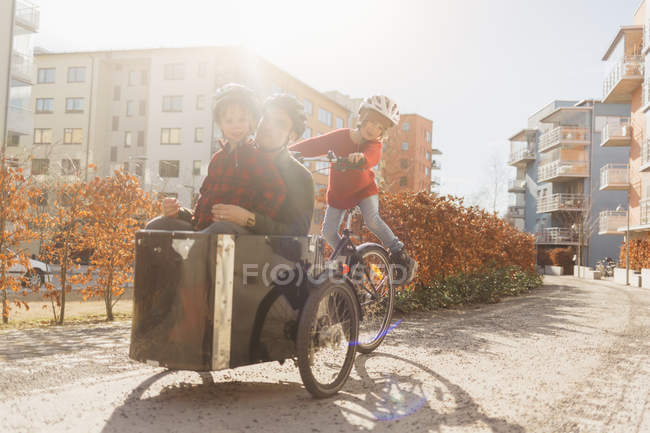 Чоловік катається на велосипеді з синами, вибірковий фокус — стокове фото